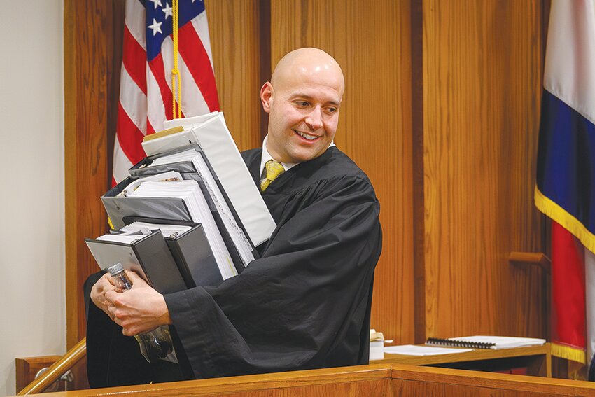 (EDS NOTE: LEAD PHOTO - IT’S ALL UP TO ANKROM NOW).Judge Derek Ankrom (CQ) has his arms full as he carries a stack of evidence books from his bench at the conclusion of a one day civil suit between residents of the University Height neighborhood and developers BK & M on Thursday, Jan. 18, 2024. The judge is not expected to rule on the suit until sometime in February..Photo by Jym Wilson ..01/18/2024 — Springfield, MO — Civil law suit one day trial against B, K &M developers over deed restrictions. Held in Greene County Circuit Court in front of Judge Derek Ankrom in Springfield on Thursday, Jan. 18, 2024..© Photo by Jym Wilson for Springfield Daily Citizen, 2024..EXIF  , NIKON Z 6_2 #3053642; 1/18/24 @6:17:39 PM; 58mm, 1/500@f3.5; 3600asa; Manual;AUTO2