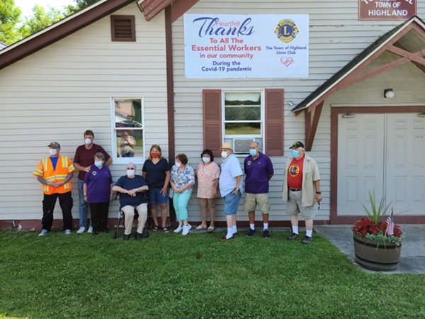 Members of the Highland Lions Club unveil a new banner in the Town of Highland thanking all of our essential workers for their dedication during the Covid-19 pandemic.