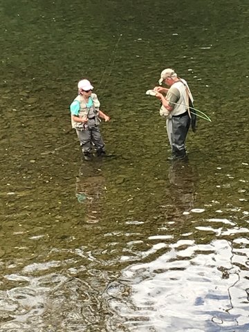 Anglers should be courteous to others and respectful of the water in which they're fishing. After catching fish, this trout fisherman is sharing a fly with another angler.