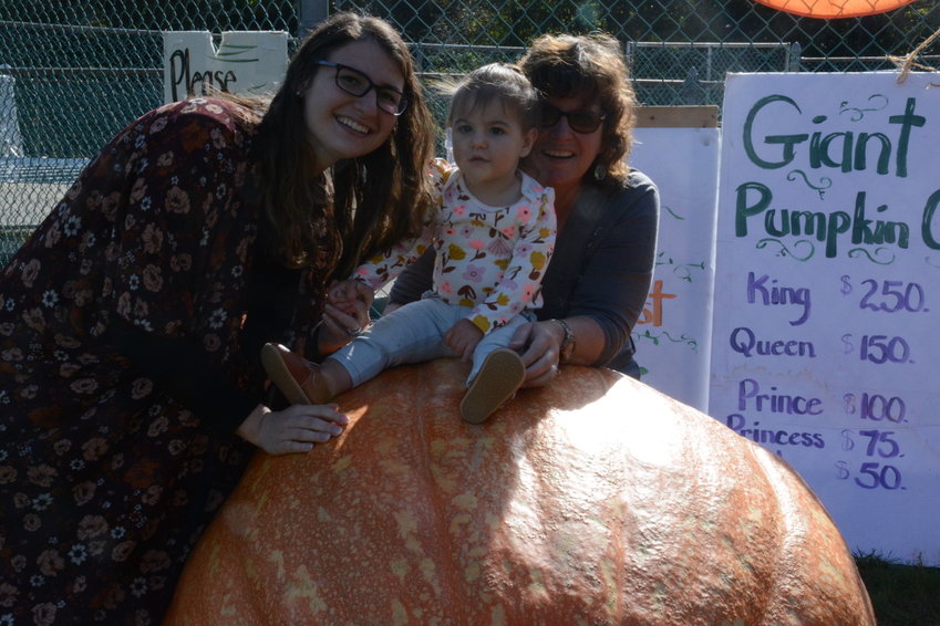One of the traditions of the event is the Giant Pumpkin Contest. Taking a closer look at this pumpkin is Ryleigh Herbert, who will soon celebrate her first birthday. She&rsquo;s pictured with her mother, Ashley (at left) and grandma Leah Exner.