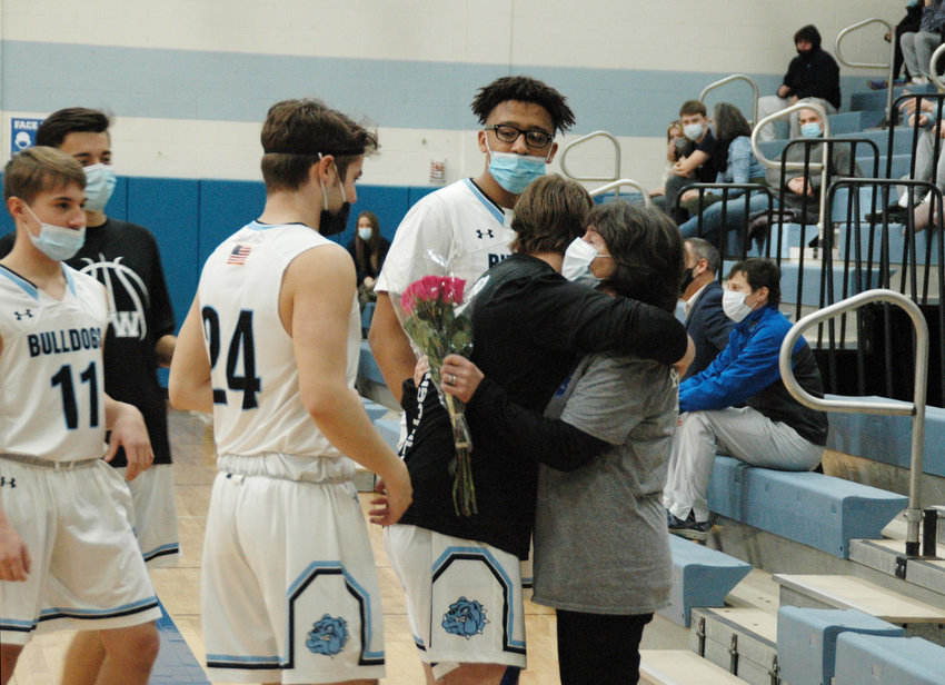 Sullivan West basketball players present flowers to Becky Ahart prior to their game against Monticello.