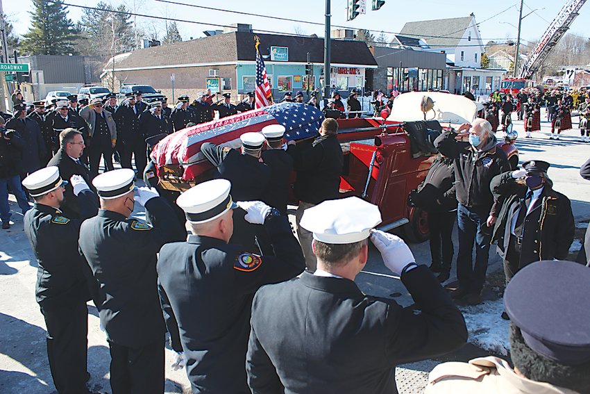 The flag-draped casket is placed onto a Forestburgh fire engine following Mass at Saint Peter&rsquo;s Church on Saturday.