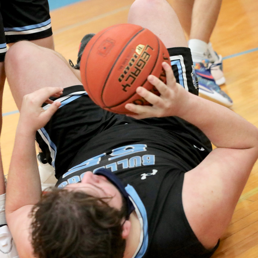 Sullivan West senior Chris Campanelli rolls on the floor holding on to a loose ball. His toughness was important in the battle on the hardwood. He led Sullivan West with 12 points on the night.