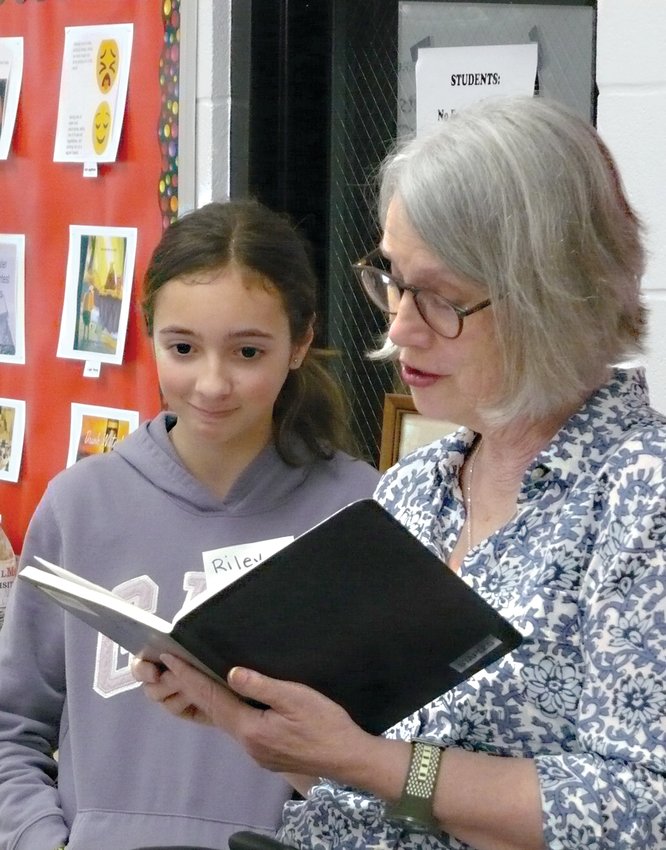 Liberty Middle School student Riley Santiago works with children&rsquo;s author Sarah Weeks in the school library. Some 17 youngsters are learning the techniques of writing in the six-lesson series of workshops.