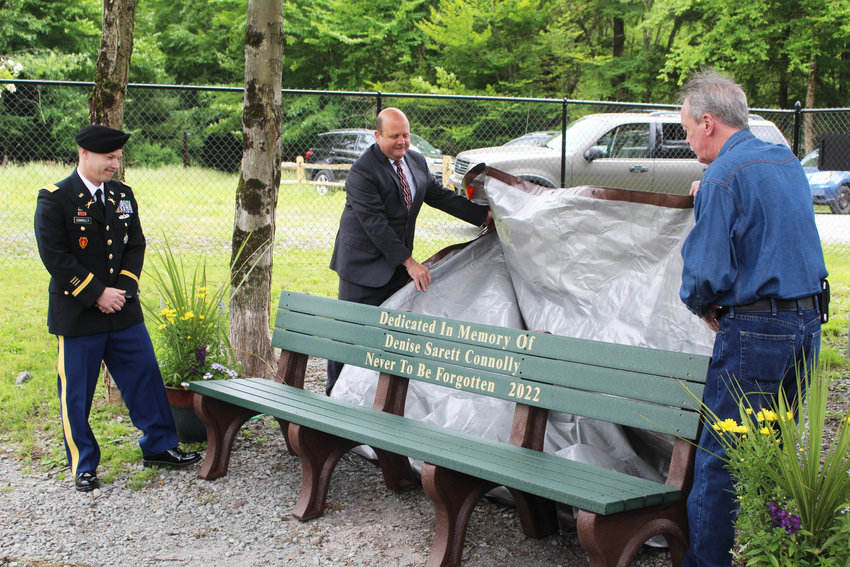 Town Supervisor Daniel Sturm (center) and Michael Connolly unveil the bench while Chris Connolly looks on. Last Saturday was also Denise Connolly&rsquo;s birthday.