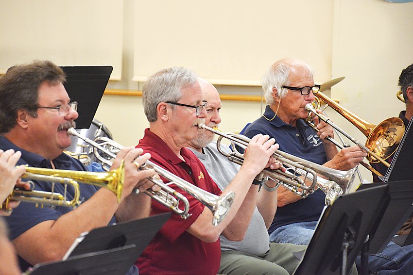 From left, band members Rossar Reynolds, Gary Siegel and Chuck Sommer (who also serves as the band&rsquo;s president) play trumpet, and Fred Fries is on the trombone.