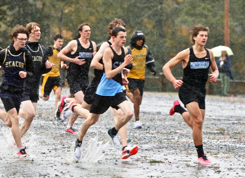 The varsity boys race bolts from the start line amidst a downpour in the first annual Woodstock Run.