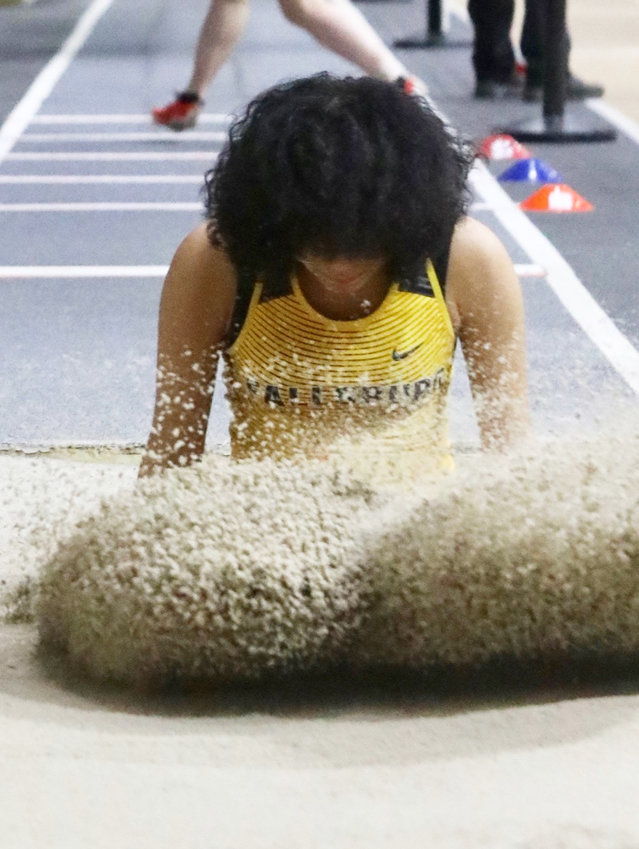 Fallsburg sophomore Hayden-Marie Herrera sends up an arc of sand after landing her third-place finish triple jump.