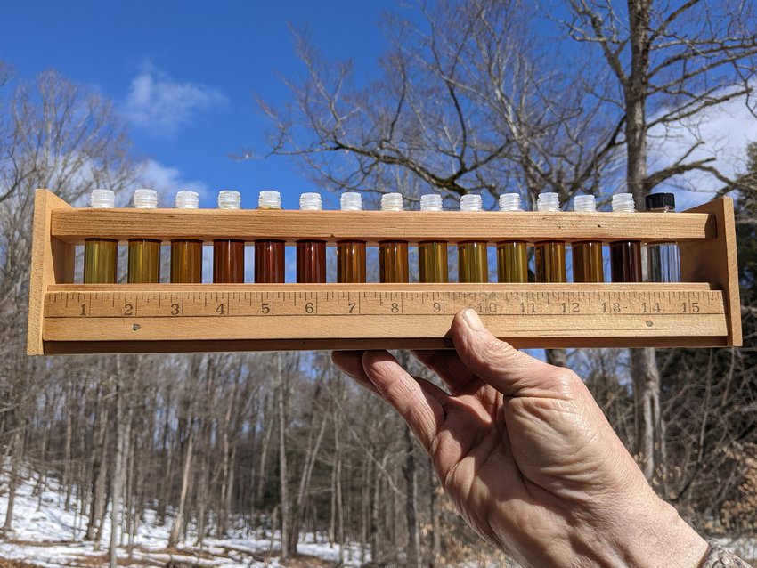 Dennis Muthig, of Muthig Farm, holds his gauge showing the various colorations of the sap/syrup throughout the sap collecting season. In the past, a dark color meant the season was over, but the weather was cooperating and the season continued as evidenced by the return to lighter colors.