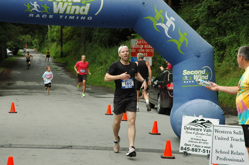 Overall 5K winner Kieran Ryan of Monticello crosses the finish line of the 25th Annual River Run.