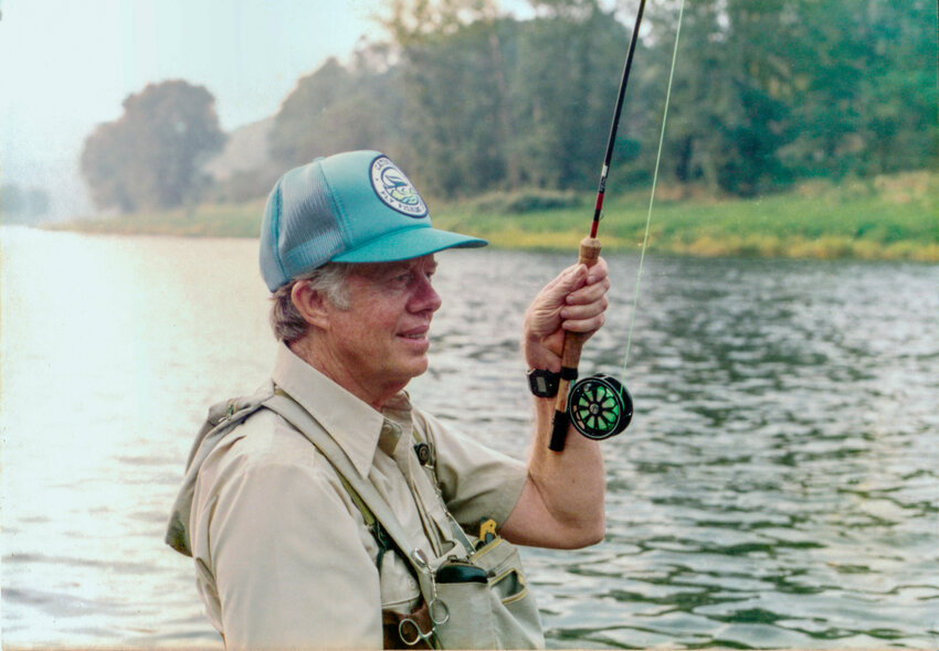 Former President Jimmy Carter reeling in a trout while fishing the Delaware River on his historic trip to the Catskills in September of 1984. He is an avid life-long fisherman and enjoys fishing with his wife, Rosalynn, well into their 90s.
