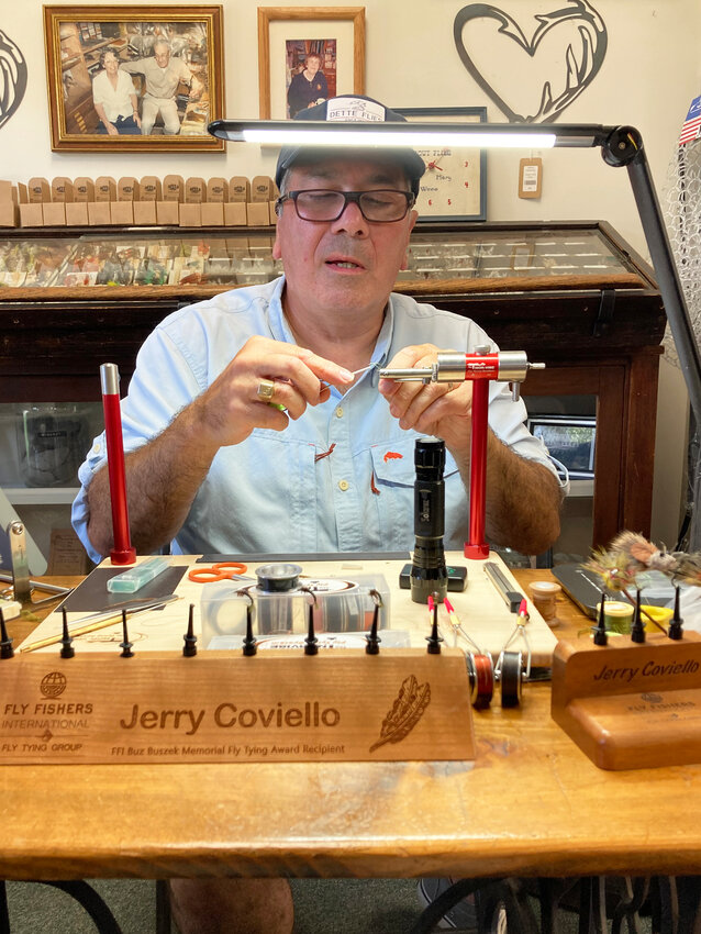 To celebrate Dette Flies 95th Anniversary, guest Fly-Tyer Jerry Coviello demonstrated how he ties his beautiful trout flies in the shop. Behind Jerry are photos of Winnie and Walt Dette, who founded  Dette Flies in 1928, along with their daughter, Mary Dette. Winnie and Walt&rsquo;s great-grandson Joe Fox, along with Kelly Buchta, are the proprietors of Dette Flies today.