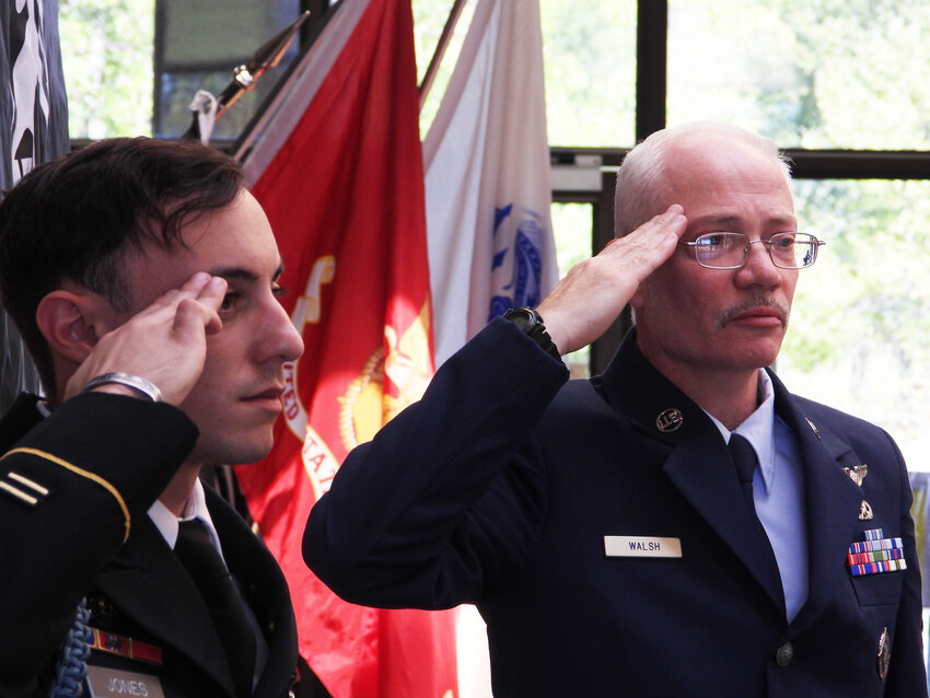 Zack Jones of the Sullivan County Veterans Service Agency, left, and Agency Director Stephen Walsh salute the flag during a rendition of Taps performed by Veteran Randy Peers.