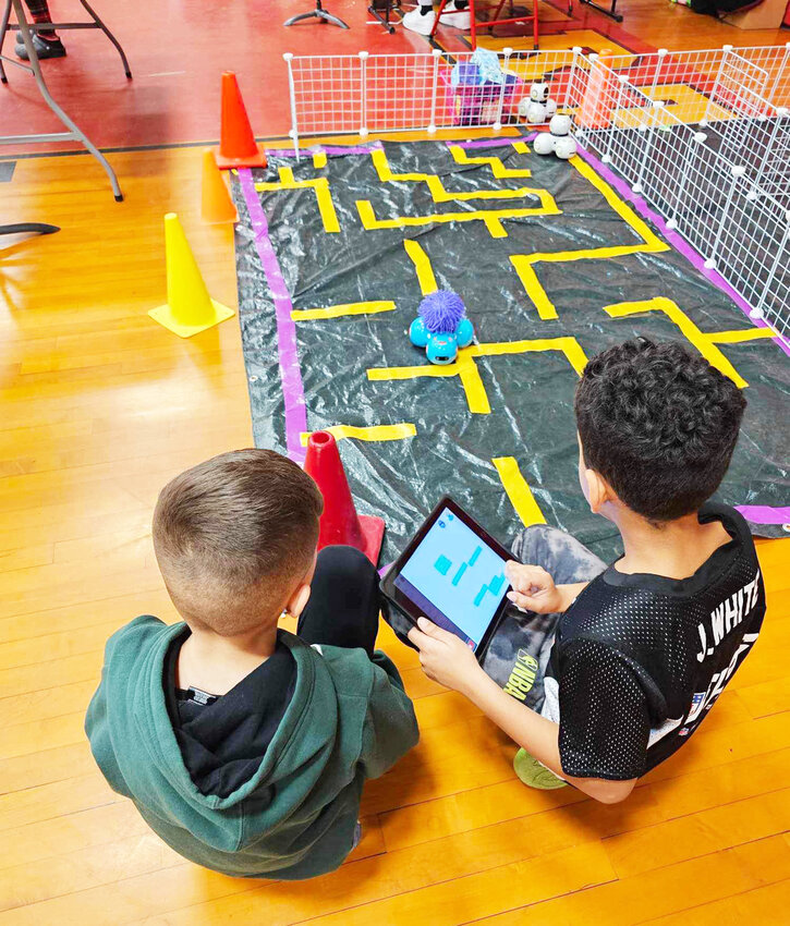 Children at the festival playing with code to control the toys on the mat.