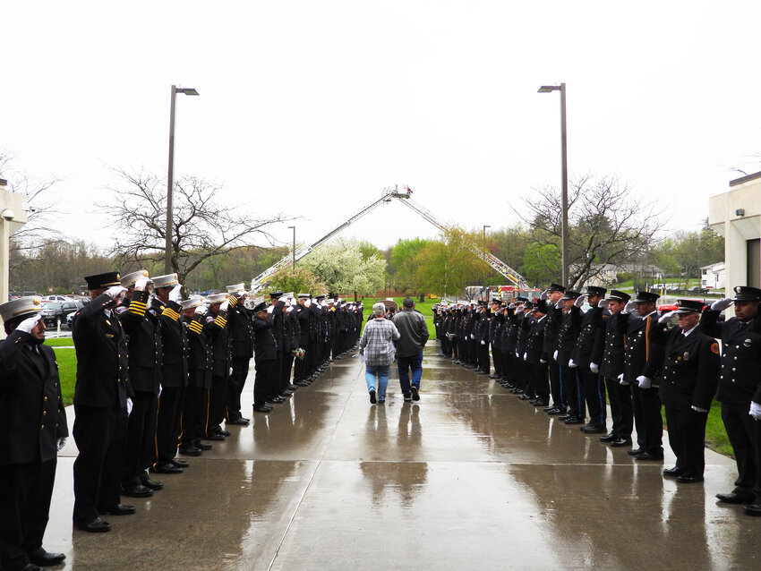 A salute from dozens of fire service 
members of various departments guided family members of the deceased towards the memorial wreath.