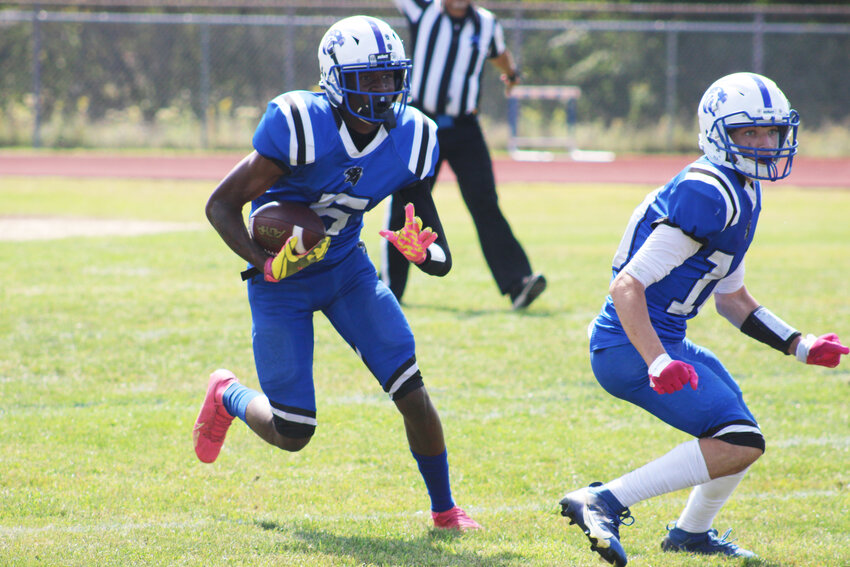 Javien Williams carries the ball in the first half with Frank McFadden leading the way against Wallkill last Saturday.