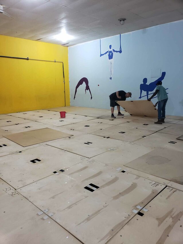 Shaun Brasington and Andrew Meade place one of the floor boards down on the gyms  newly installed spring floor.