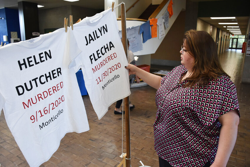 District 5 Legislator Cat Scott, who chairs the Health & Human Services Committee, holds the shirt of a victim of domestic violence at The Clothesline Project at the Government Center.