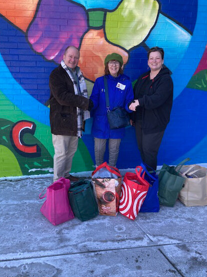 Christopher Palmer, assistant principal, Jean Eifert, Wolf Lake Neighbors Foundation, and Joana Dutcher, teacher and Care Closet Coordinator at Cooke, with donations.