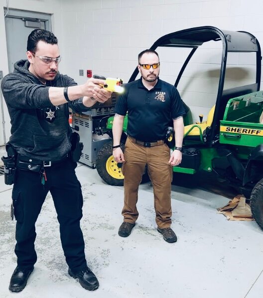 From Left to Right is Deputy James Lynch in shooting stance with the new TASER 7 while Sergeant Charles Blackburn looks on.