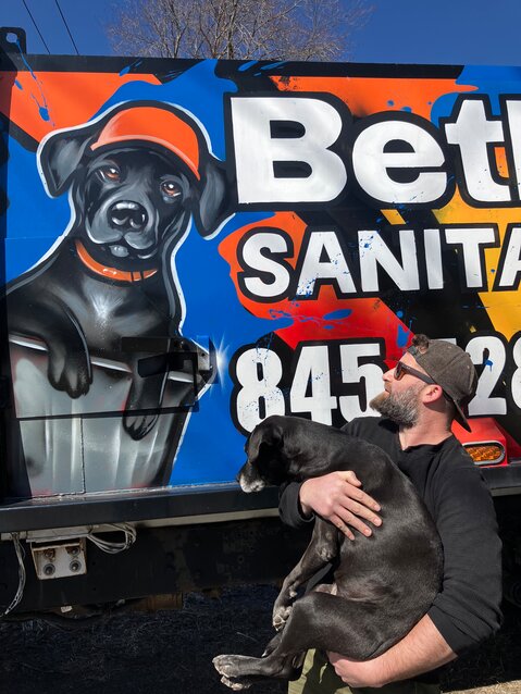 Andrew Liff and his dog Sadie admire the mural on their truck.