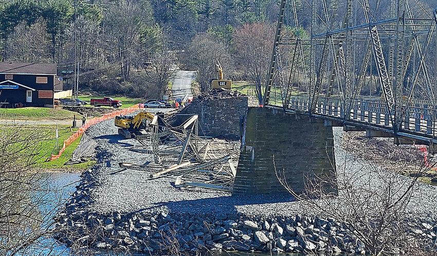 The New York span of the 1902 Skinners Falls-Milanville Bridge was mechanically demolished onto a stone causeway on April 17, as witnessed from the Pennsylvania shore. The PA span was then dropped into the river on April 21, after the nationally-listed historic bridge was deemed to be in danger of an uncontrolled collapse.