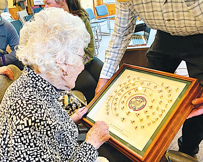 Joan Wulff, First Lady of Fly Fishing, views the exquisite frame of An Adams For Ed, shown to her by CFTGuild Vice-President John Apgar.