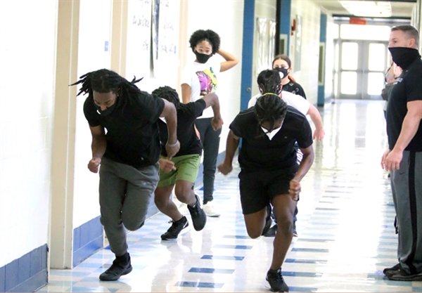 Monticello sprinters led by Jaykim Abraham (front left) take off a loop around the Monticello Middle School as Coach Matt Buddenhagen looks on.