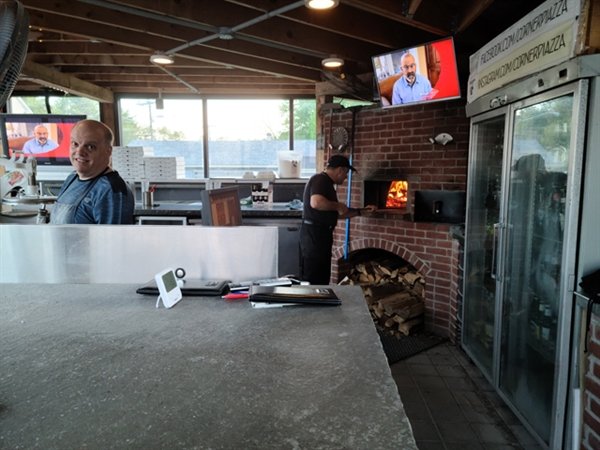Local businessman and philanthropist, Lou Monteleone and his brother Frank, make the specialized thin crust pizzas in their wood burning oven at the popular Pizza Piazza in Eldred.