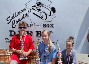 From left, local champions Mason Smith (superstock), Cassie Wolcott (masters) and Cora Friedenstine (stock).