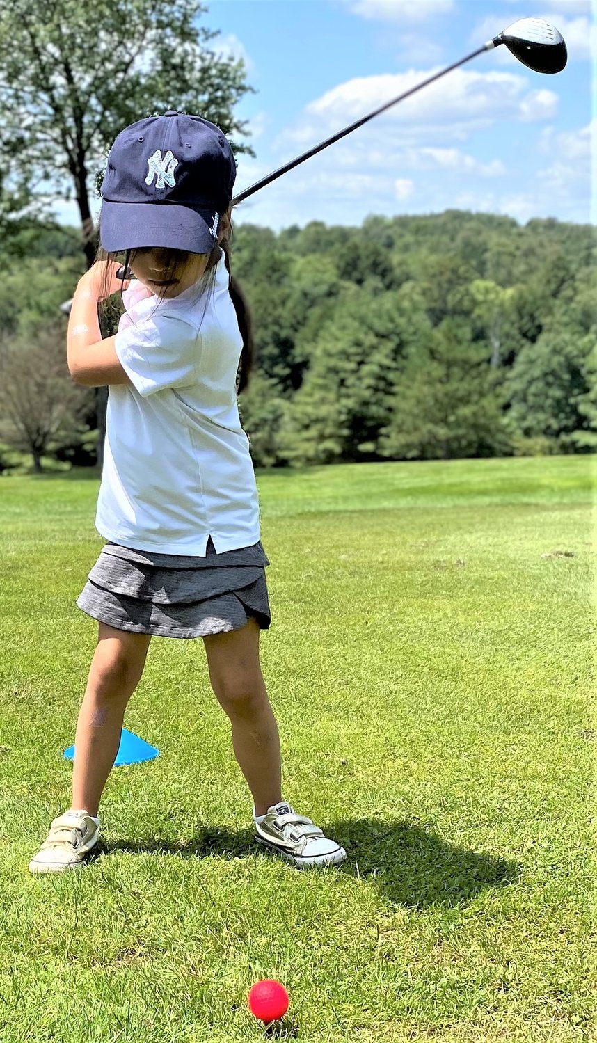 From left to right, camper Giuliana Gallo gets in a good swing, lefty Quinlian Kelly practices and Kevin Kubenik displays a nice golf swing.