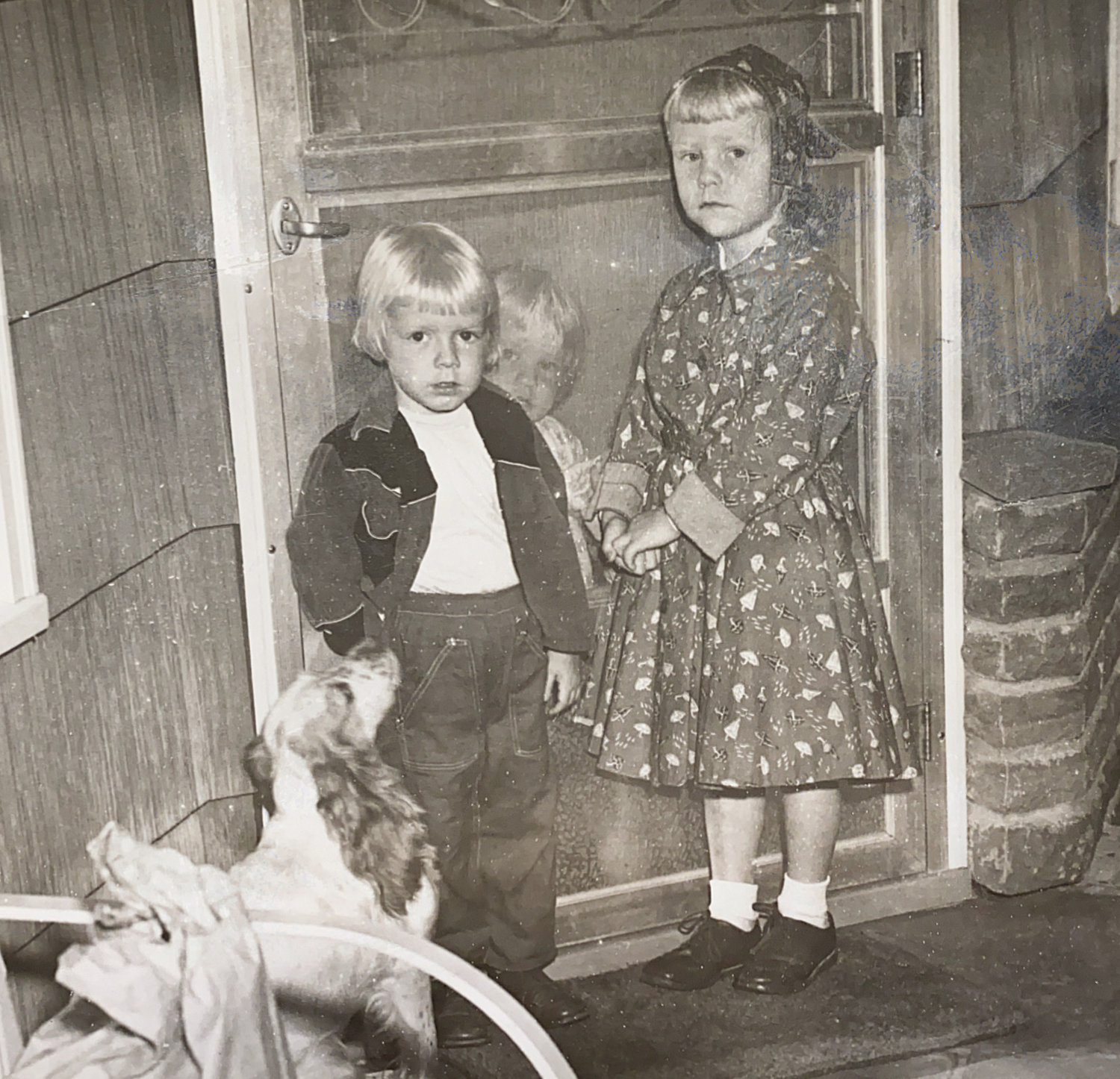 September 3, 1957- Kathy (right) on the first day of kindergarten. Sister Billie (center) is behind the screen door. Sister Laurie (left) is none too happy at not being able to go to school yet. Our faithful dog Sugar stands at the ready.