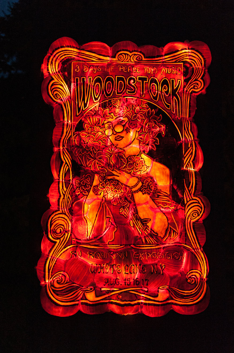 Glowing and groovy Woodstock pumpkin art on display.