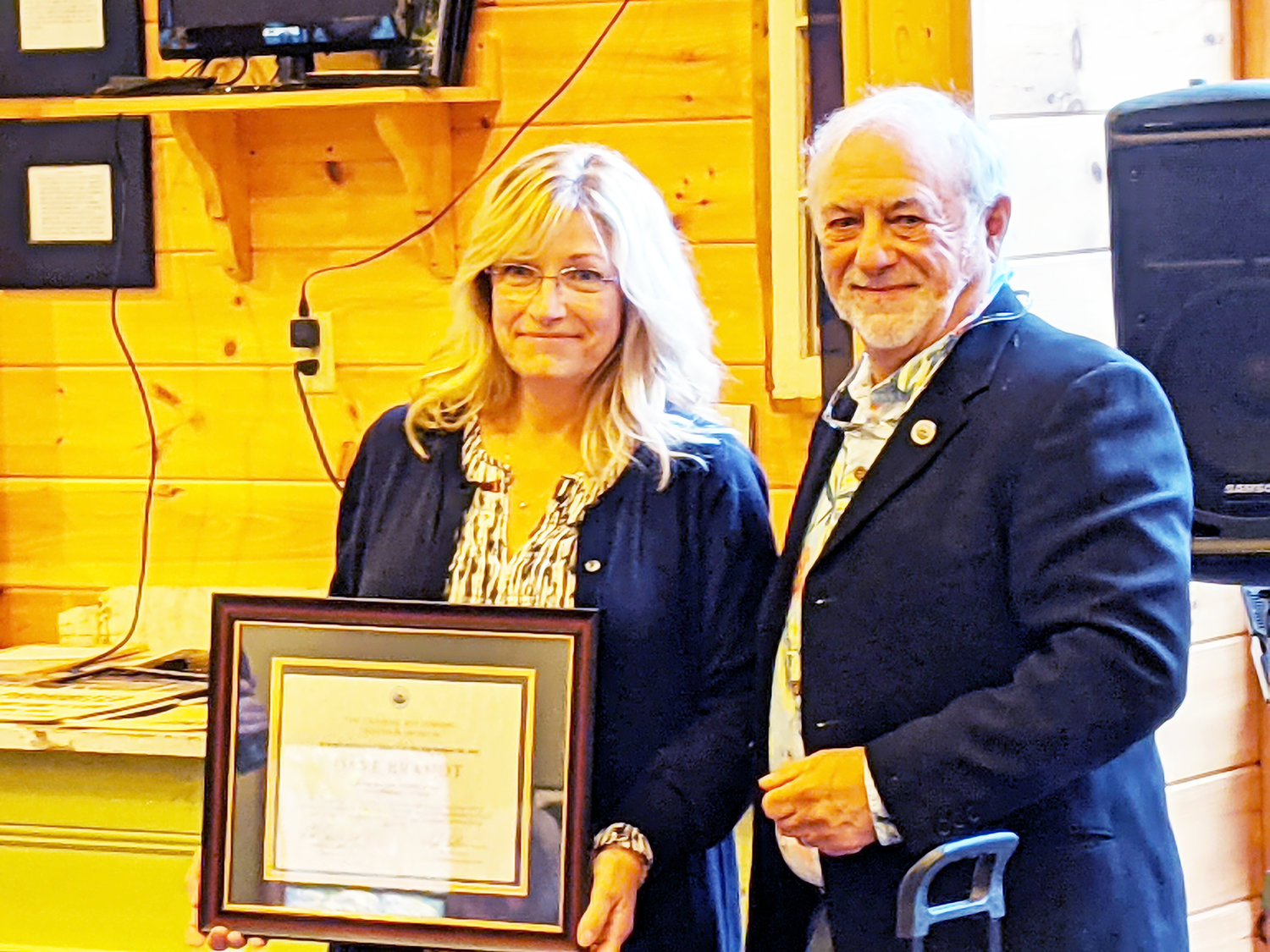 Debra Prendergast, granddaughter of Dave Brandt, accepts the 2021 Hall of Fame award on his behalf from Ted Patlen at the Catskill Fly Fishing Center and Museum ceremony in Livingston Manor.