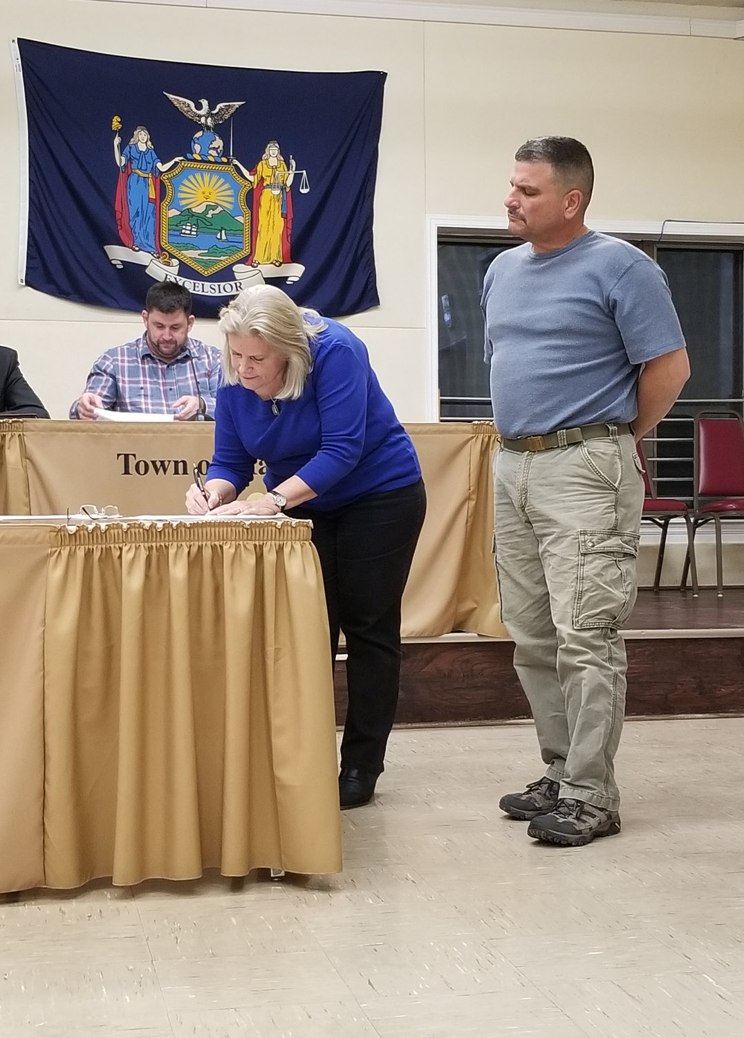 Town Supervisor Janet Lybolt signs the collective bargaining agreement followed by John Stasko, a highway department employee.