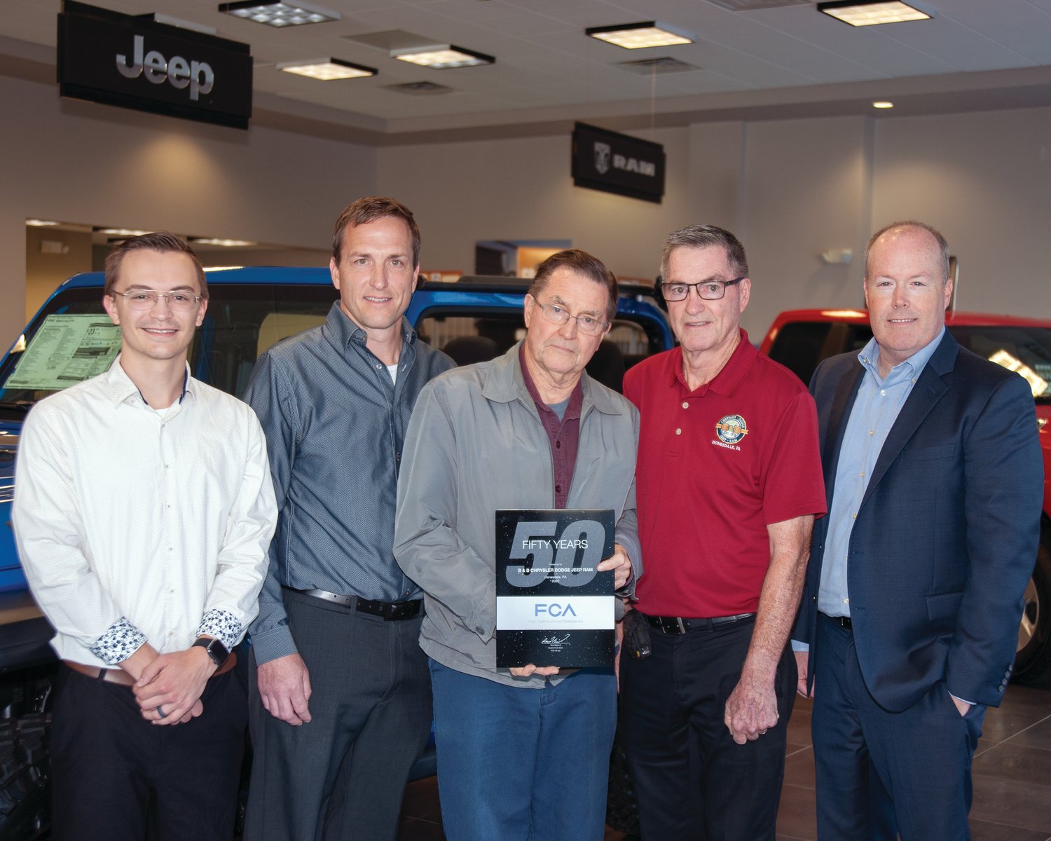 Marking 50 years since three Carmody brothers purchased the Dodge automobile franchise in Honesdale, Mason Carmody (left); Stephen Carmody Jr., John Carmody, and Stephen Carmody Sr. recently welcomed John M. Mack, director of Chrysler Group’s Mid-Atlantic Business Center to the dealership.
