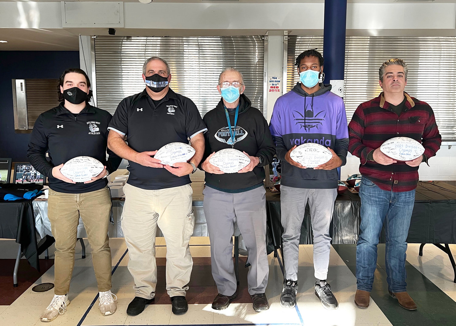 The coaching staff each received a football signed by all the players on the team. From left to right: Justin Diehl, John Hauschild, Ron Bauer, Ronj Padu and Shane Cruz.