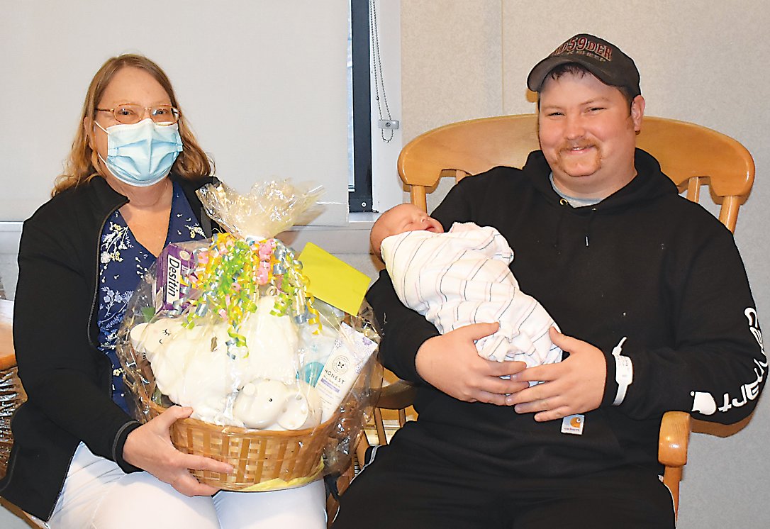 From left to right: Joyce Bannon, RN, presents Austin and baby Dixie with a gift basket.