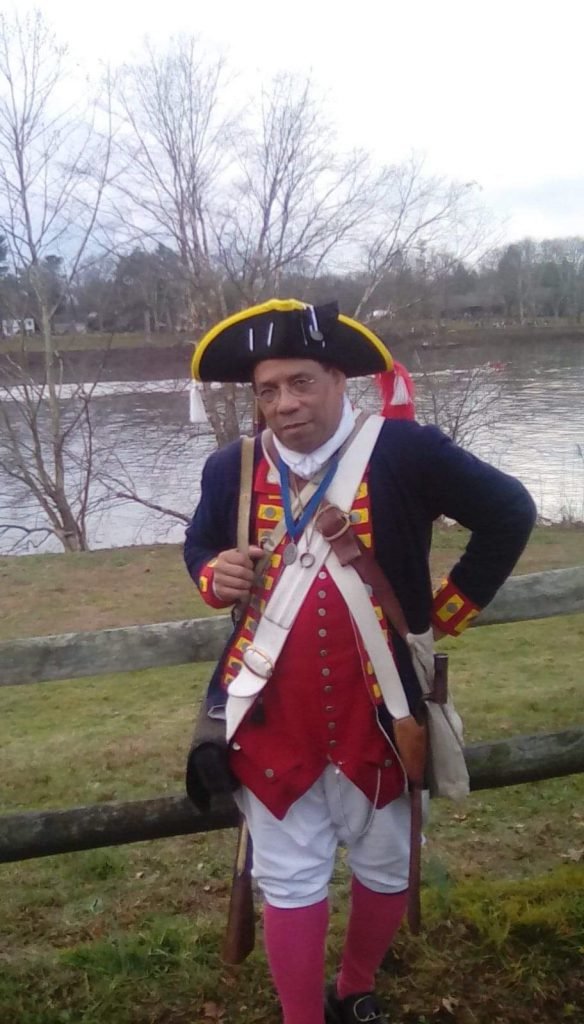 Noah Lewis as Revolutionary War soldier Ned Hector, with the Delaware River in the background.