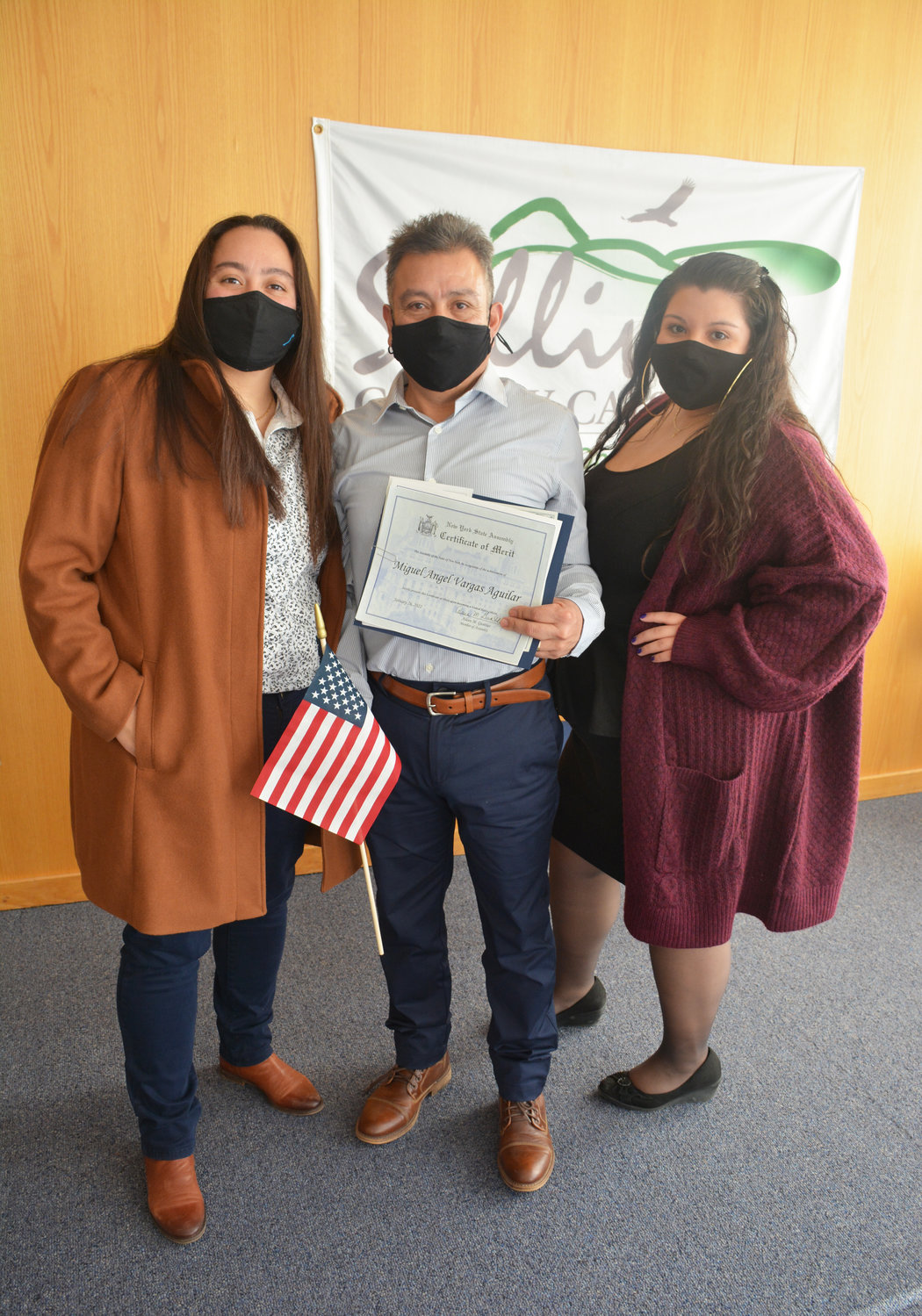 Miguel Angel Vargas Aguilar shows off his certificate with his two daughters Selena (at left) and Liliana, by his side.