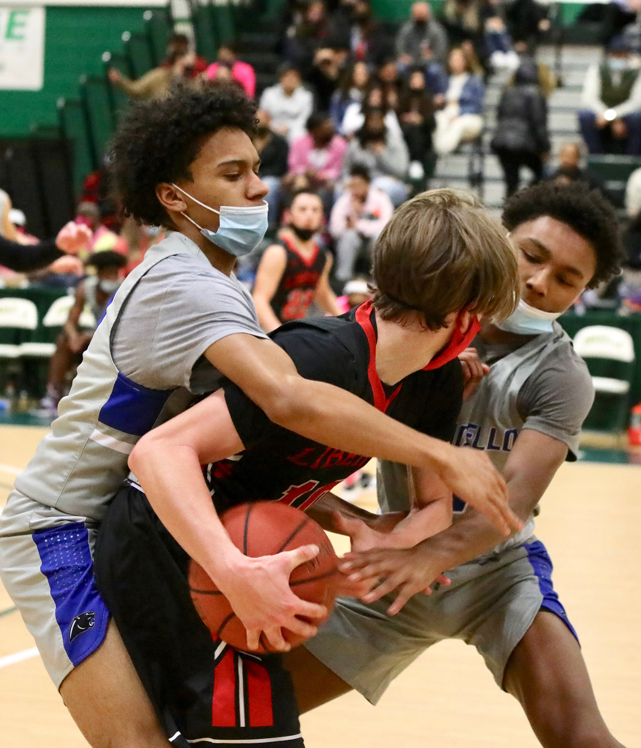Monticello’s Jadden Bryant (left) and Judah Brown smother Liberty’s Ethan Werlau with their pressure in the Panthers’ 68-52 win over the Indians.