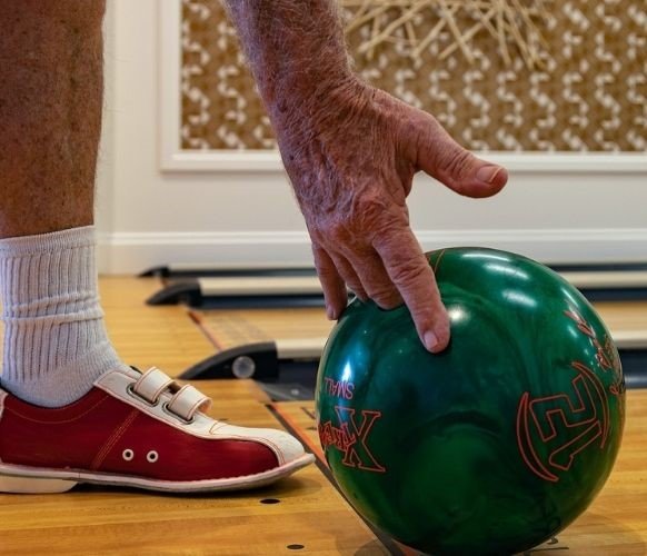 A bowler getting ready to throw his bowling ball using the no-thumb grip.