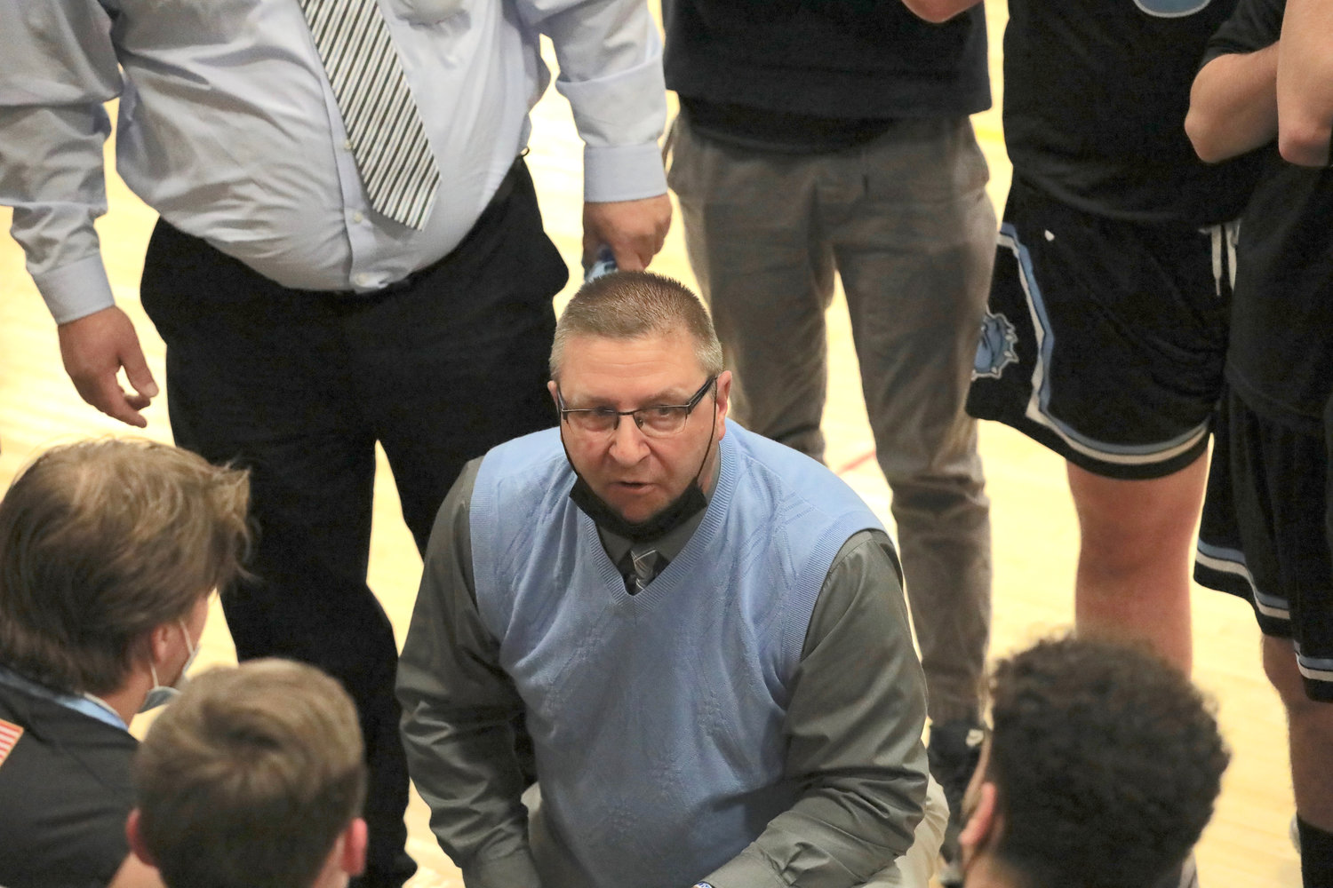 John Meyer kneels down to address his players during a timeout.