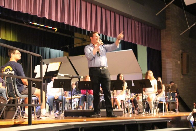 Music educator Andrew Verdino and students demonstrate band instruments.