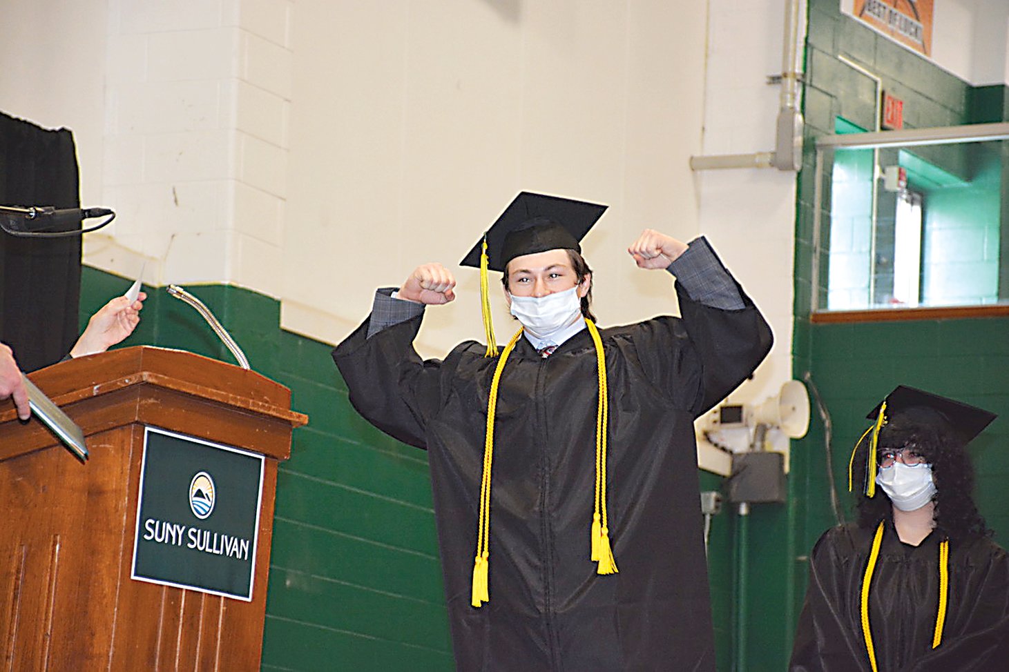 SUNY Sullivan wrestler Liam Bullock flexes across the podium en route to his diploma.