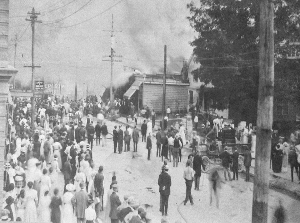A crowd watches as fire destroys a large part of the village's business district on Friday the thirteenth, June 13, 1913.
