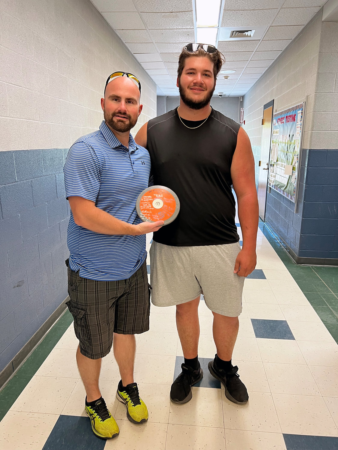 Chris Campanelli presents Coach Steve Rogers with a signed discus as a token of his and the team’s appreciation. Rogers, a former Section 9 champion thrower, was instrumental in Campanelli’s arc of progress. Prior to his emergence as the Sullivan West boys track coach, Campanelli was by and large self-taught.