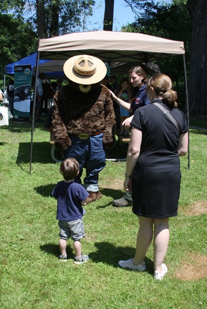 A young child and his mother greet Smokey the Bear at the 15th Zane Grey Festival.