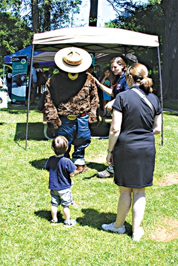 A young child and his mother greet Smokey the Bear at the 15th Zane Grey Festival.