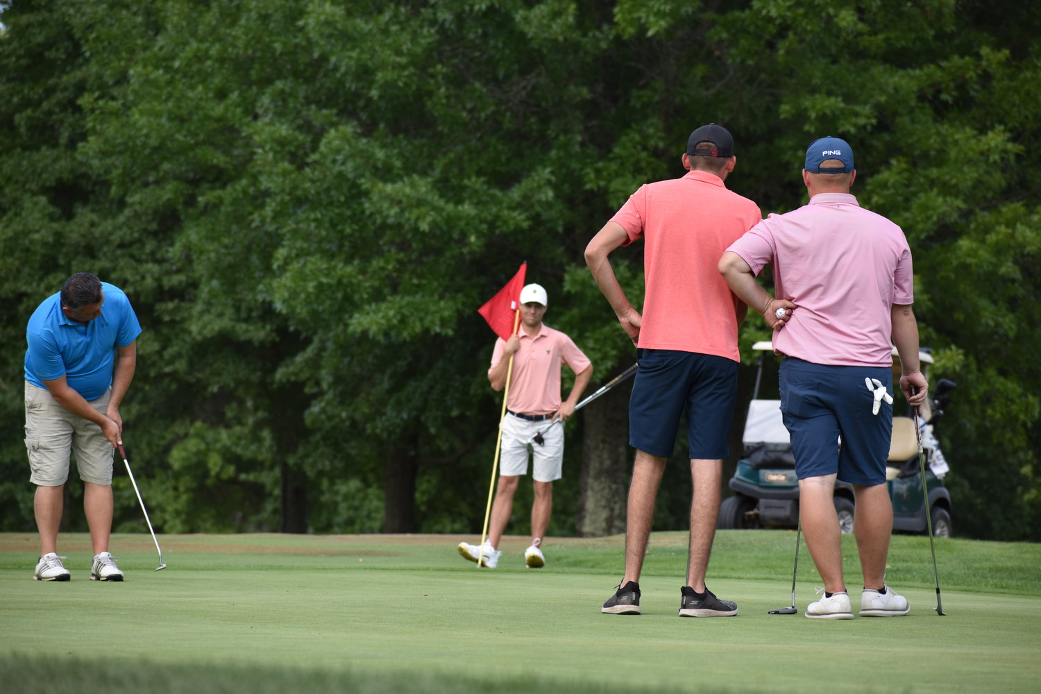 Michael Decker putts on 16. The ball took an unfortunate hop out of the hole and led to Semenetz and Winski tying the hole and keeping a two-up lead going into 17. Looking on is Sean Semenetz, holding the flag, Michael Scuderi and Joe Winski, right.
